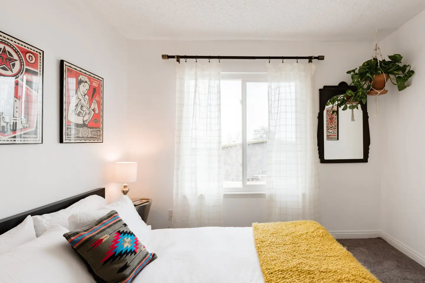 Bedroom with art posters and yellow blanket