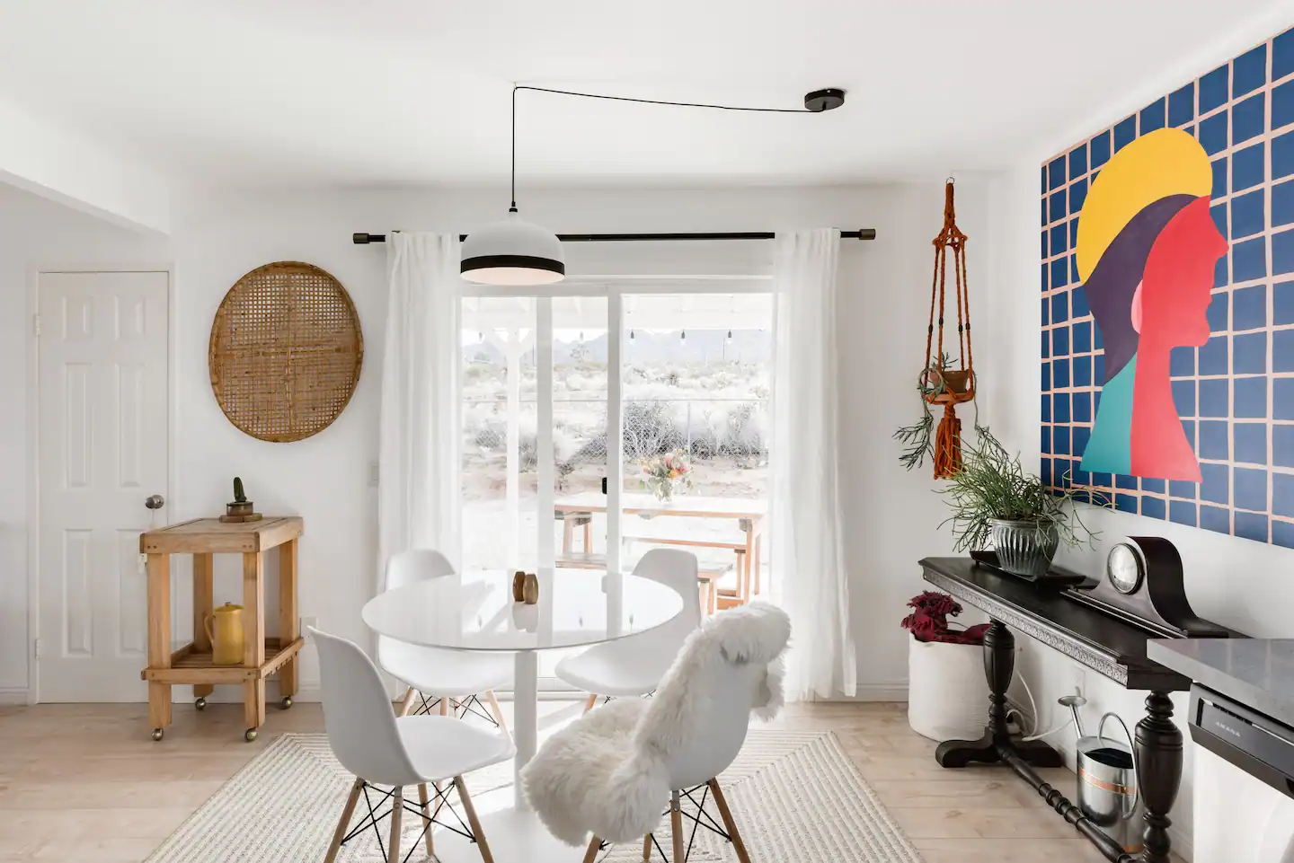 Dining table with sliding glass door and colorful painting