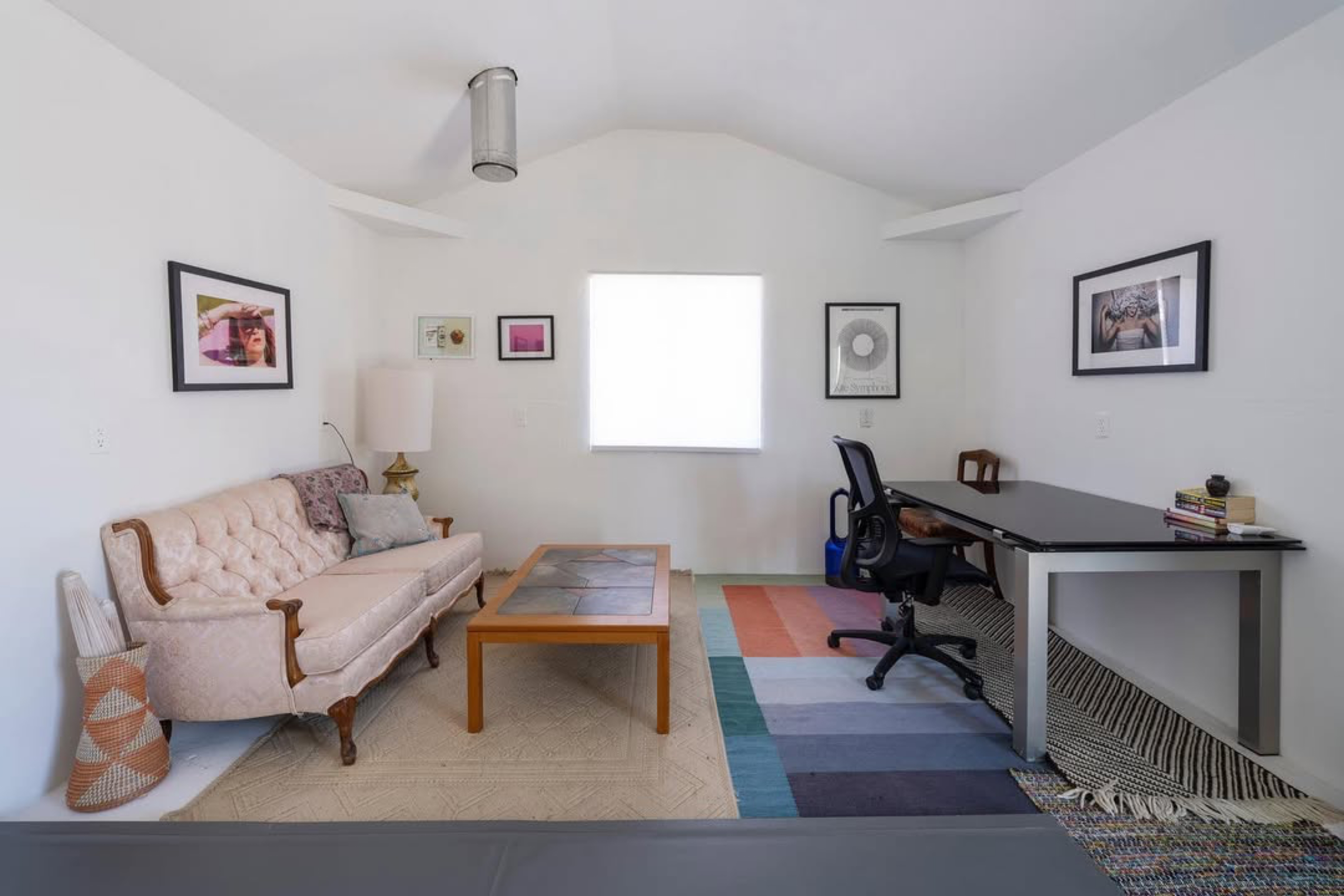 Cozy living space with a desk and pink sofa